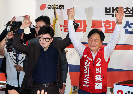 국민의힘 한동훈 대표가 지난 27일 인천 강화군 강화읍 박용철 강화군수 보궐 선거 후보 선거사무소에서 열린 선거대책위원회 발대식에서 박 후보자와 함께 손을 들어 인사하고 있다. <연합뉴스>